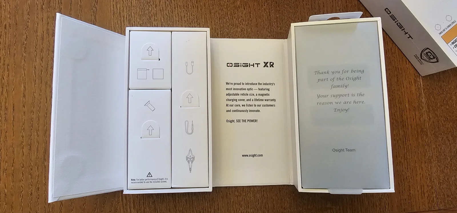 Osight XR retail packaging opened to show the magnetic charging cover, optic, and accessory layout