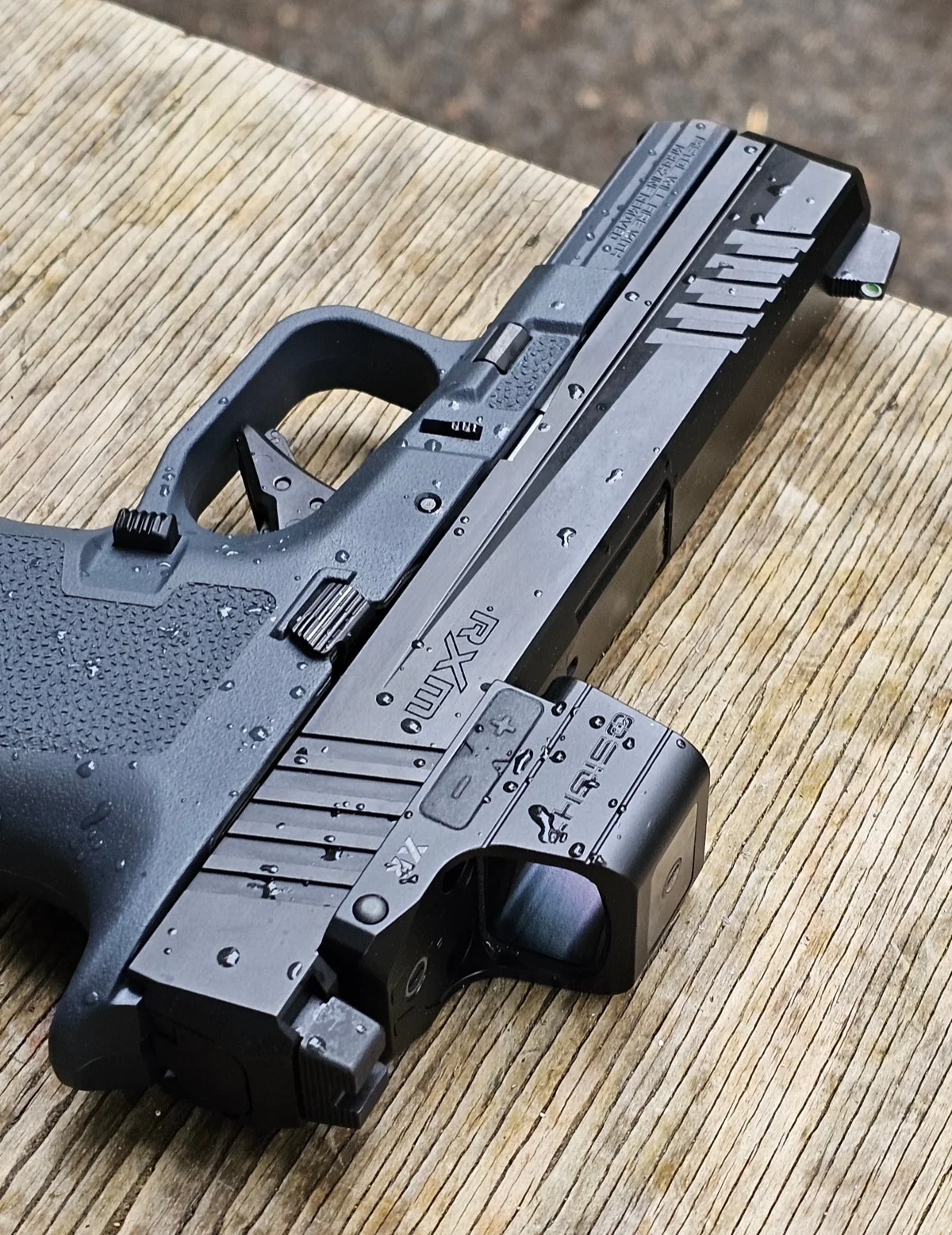 Ruger RXM and Osight XR beaded with rainwater on the slide, frame, and optic housing after shooting in the rain