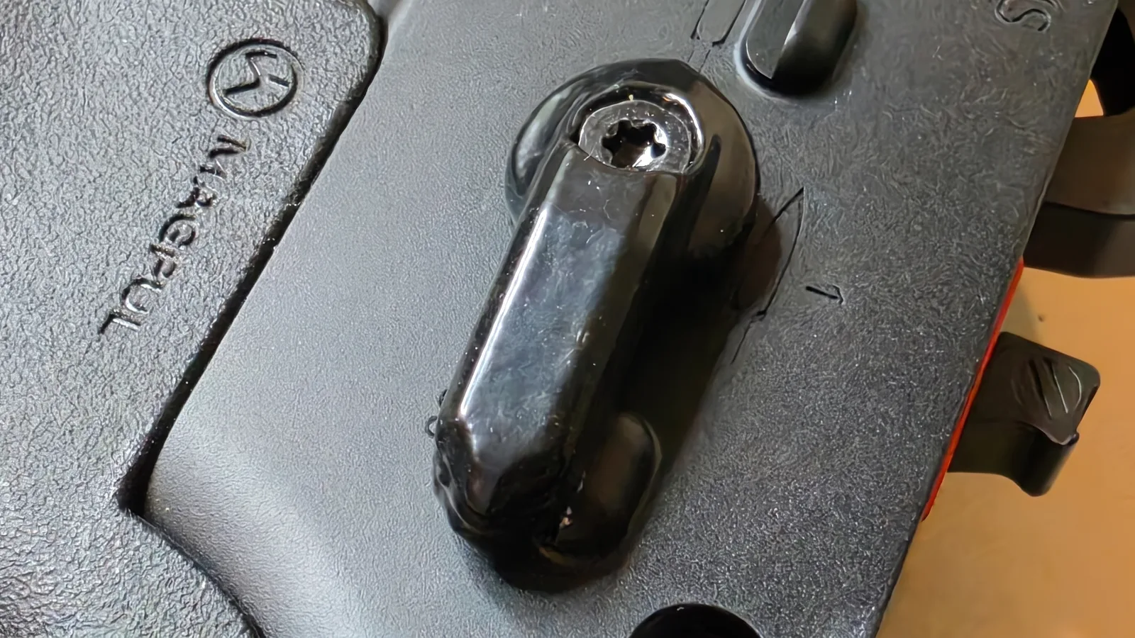 The Triggered Company SBW ambidextrous selector lever installed on an AR-15 lower receiver next to a Magpul pistol grip, with the Torx screw that retains the lever visible in its center