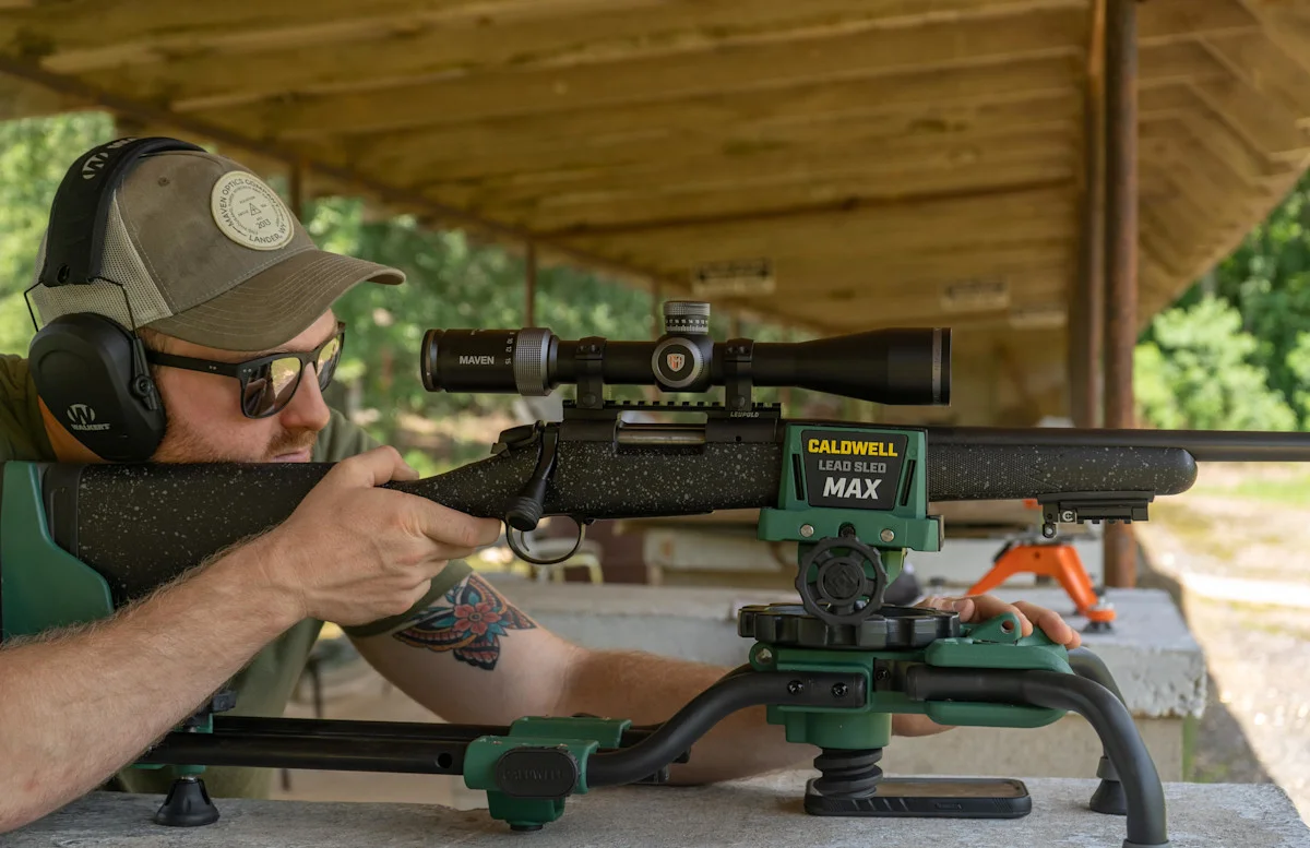 Shooter behind a scoped bolt-action rifle on a Caldwell Lead Sled rest at an outdoor range