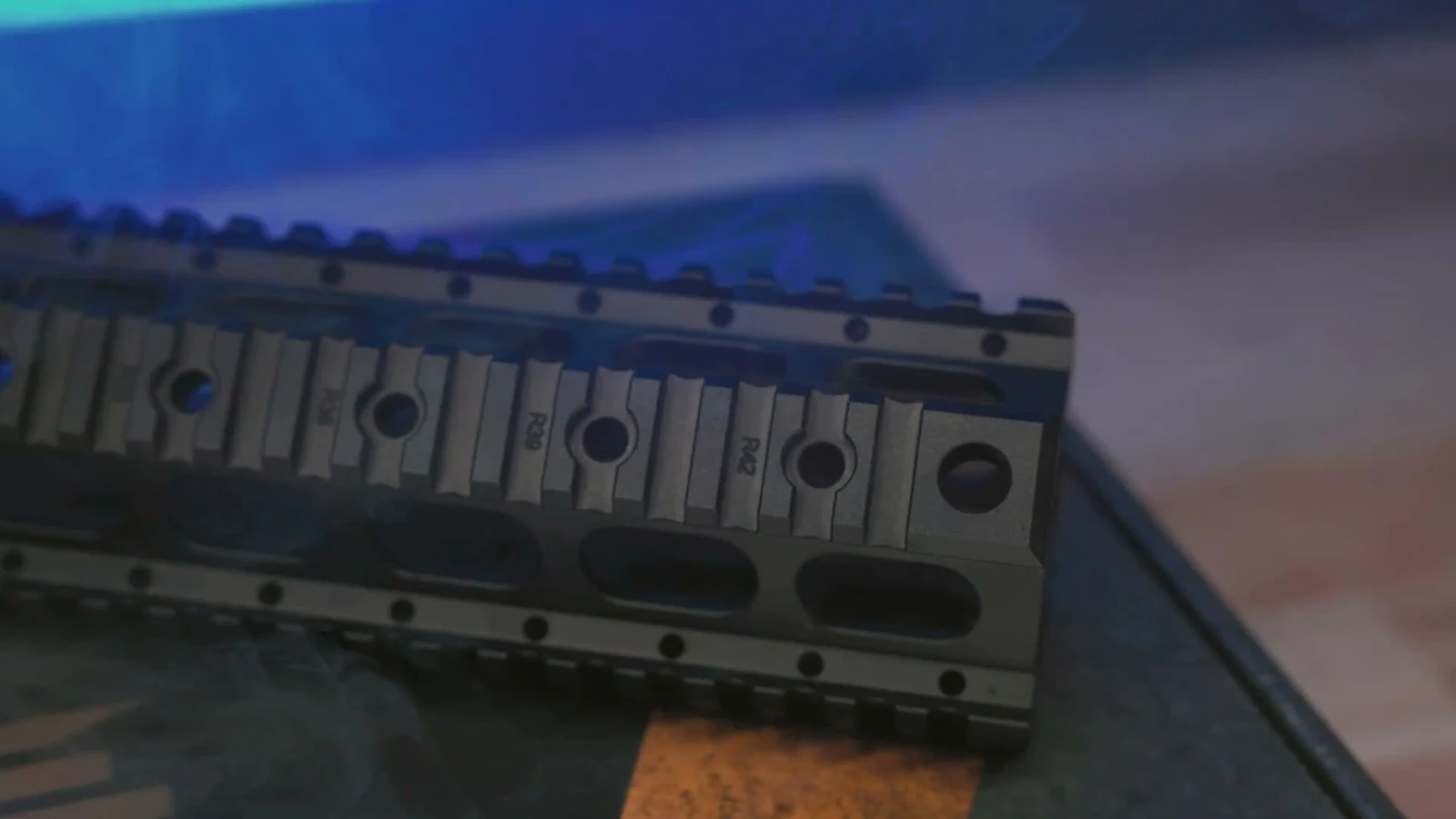 Close-up of the Sabre-10 quad rail handguard showing engraved rail slot numbers R36, R39, and R42 alongside oval lightening cuts