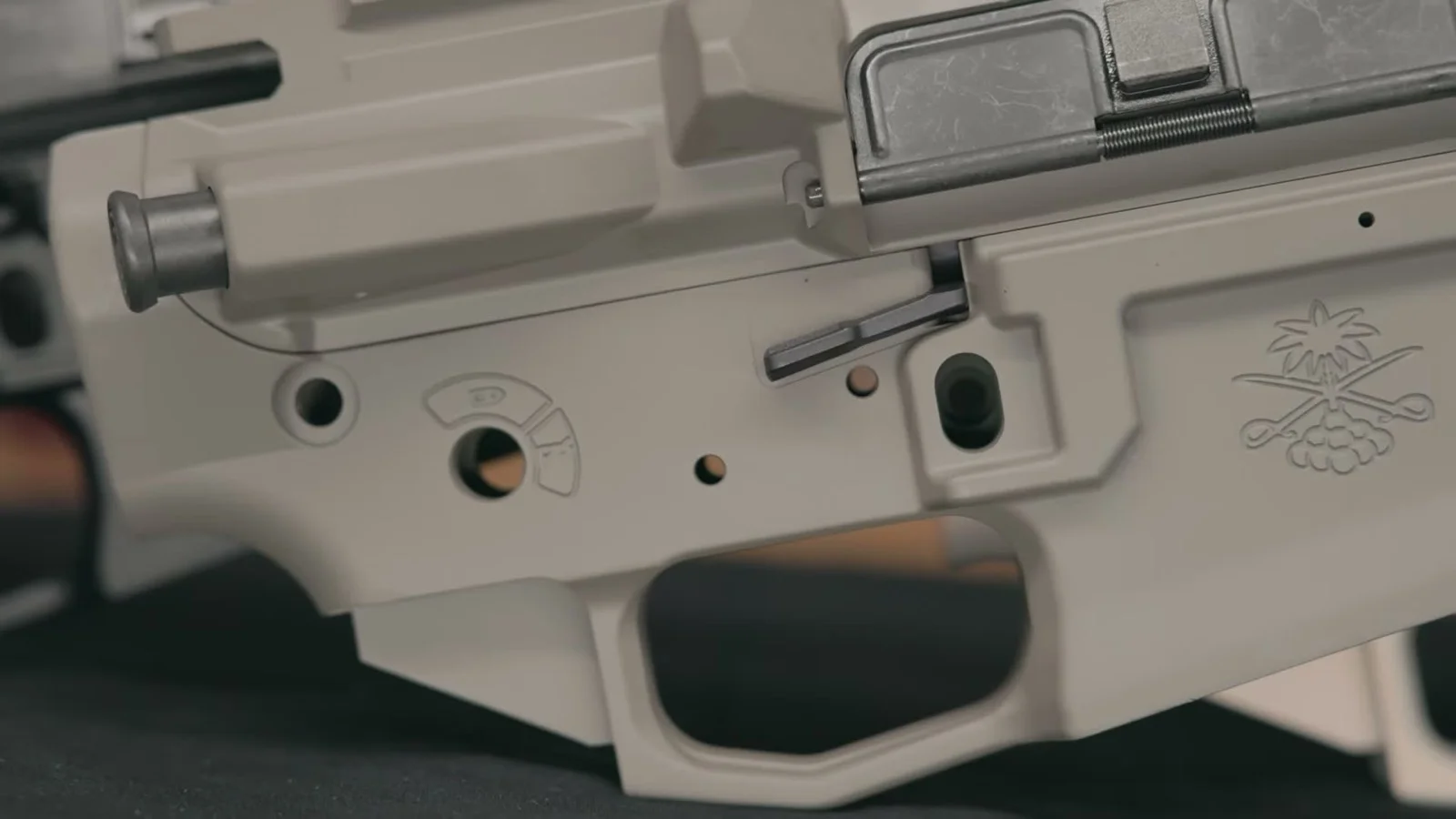 Champagne-finish PSA Sabre Enhanced lower close-up showing the flared magwell, machined-in trigger guard, and ambidextrous bolt release
