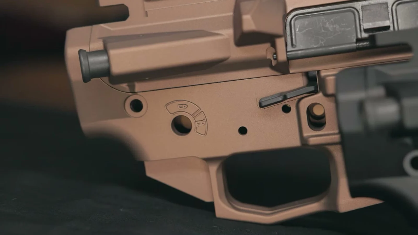 Burnt Bronze PSA Sabre Enhanced lower in close-up showing the right-side ambidextrous bolt catch and release paddle and the safety selector markings