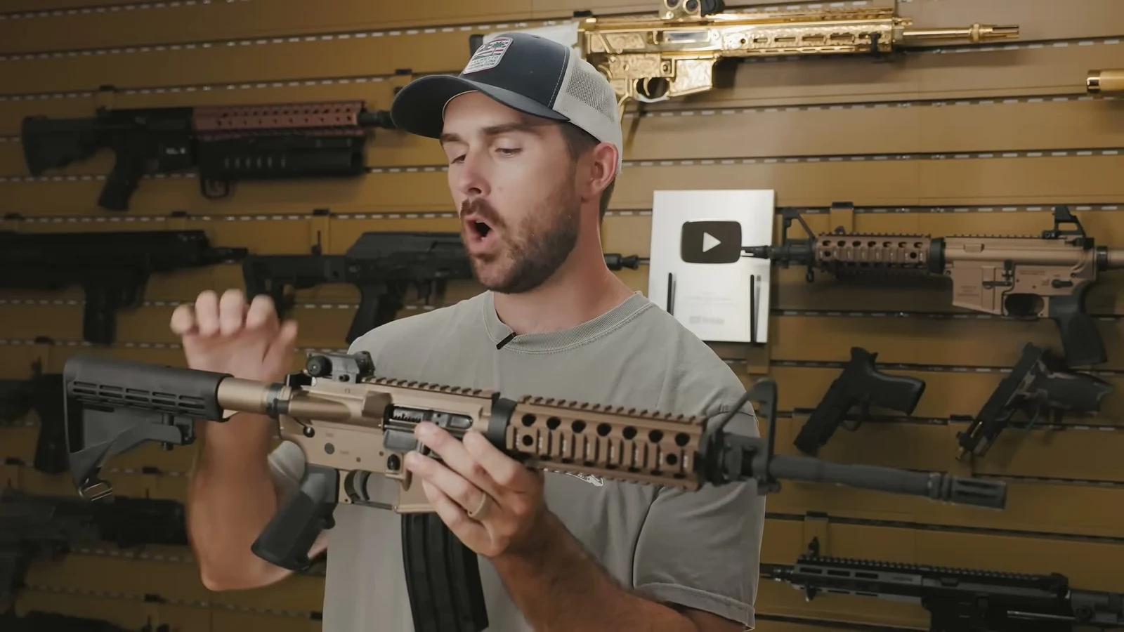 Tan anodized PSA Sabre M4A1 held horizontally showing the tan upper receiver, tan drop-in quad rail, tan buffer tube, and black M4 stock and A2 grip