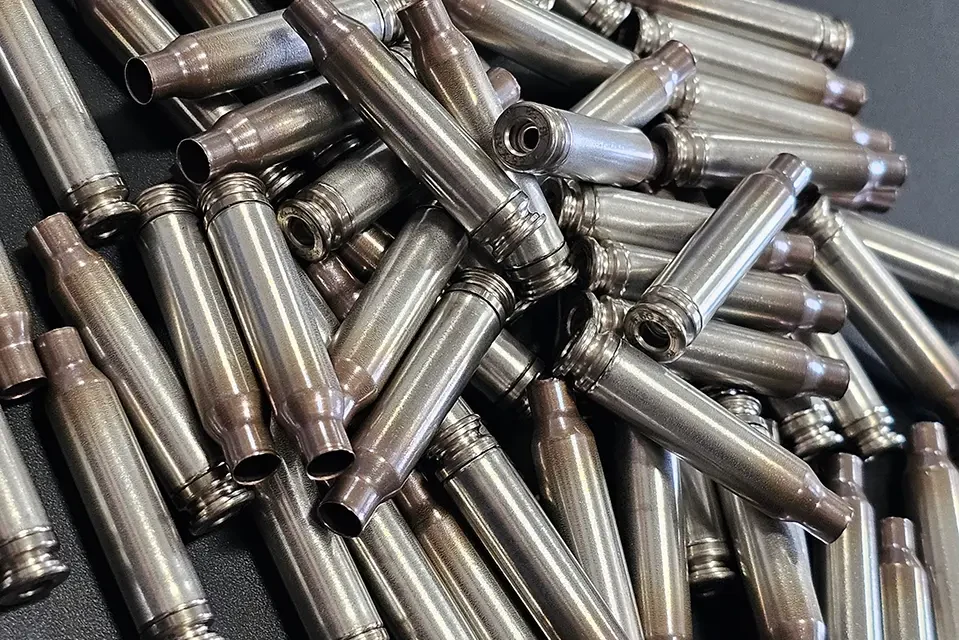 Pile of Shell Shock 5.56 NATO NAS3 nickel-alloy cartridge cases with primer pockets visible