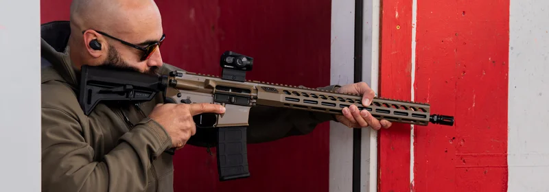 SIG M400 Forge in Moss Green Cerakote being fired at a range, showing the 16-inch barrel and mid-length gas system