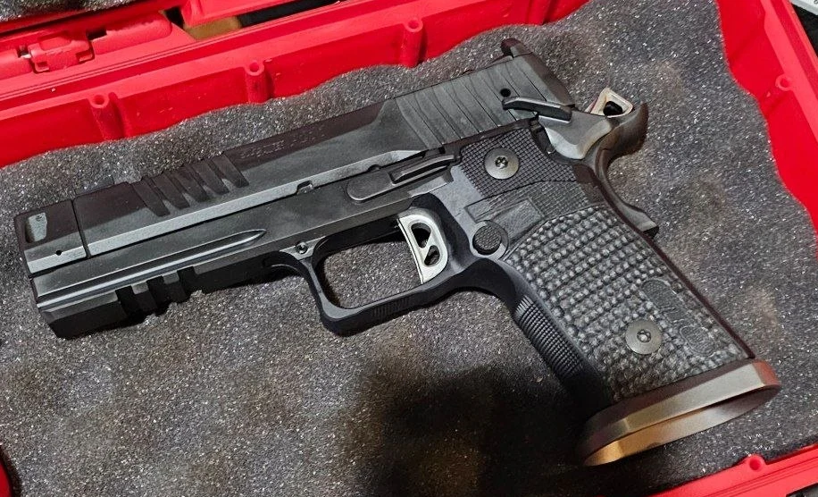 The author's SIG P211-GTO showing the Mach3D compensator, full-length railed dust cover, and textured G10 grip panels