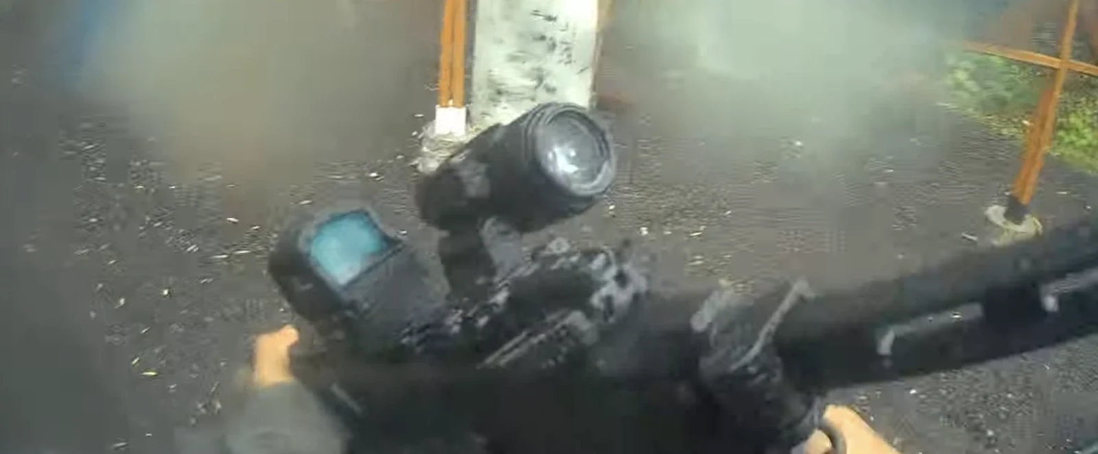 Overhead view from a chest camera of the ROMEO8T-AMR and its magnifier on a rifle during a rain-soaked 2-gun stage, water beaded across the receiver and the camera lens