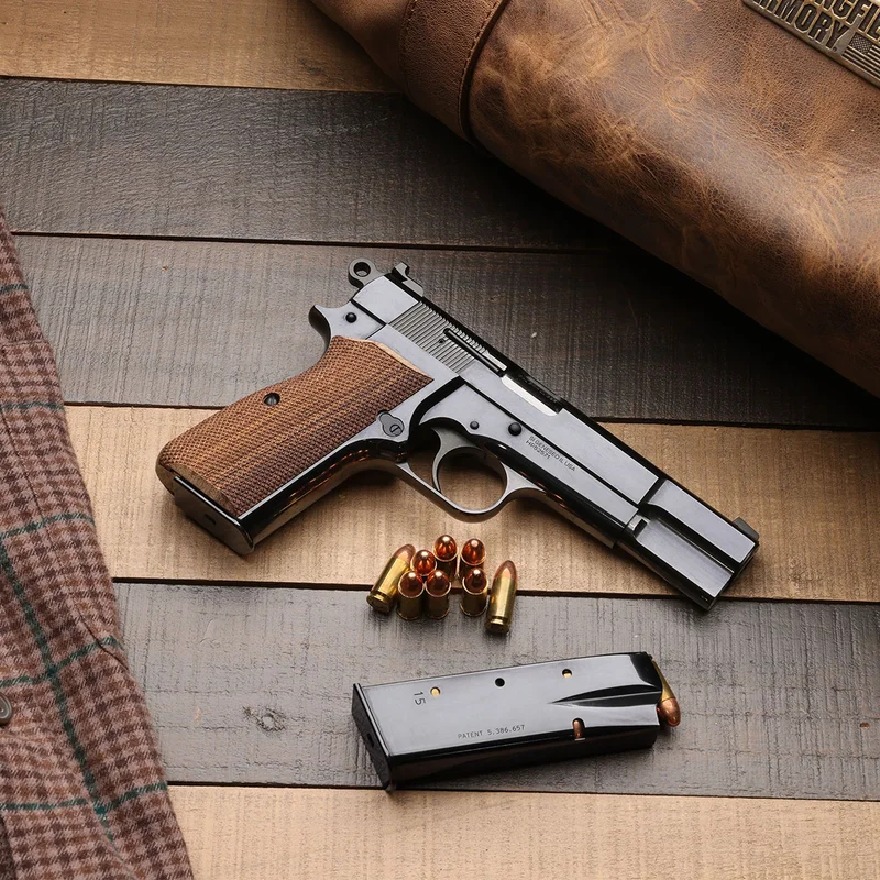 Springfield Armory SA-35 9mm pistol with polished blued finish and checkered walnut grips on a wooden surface