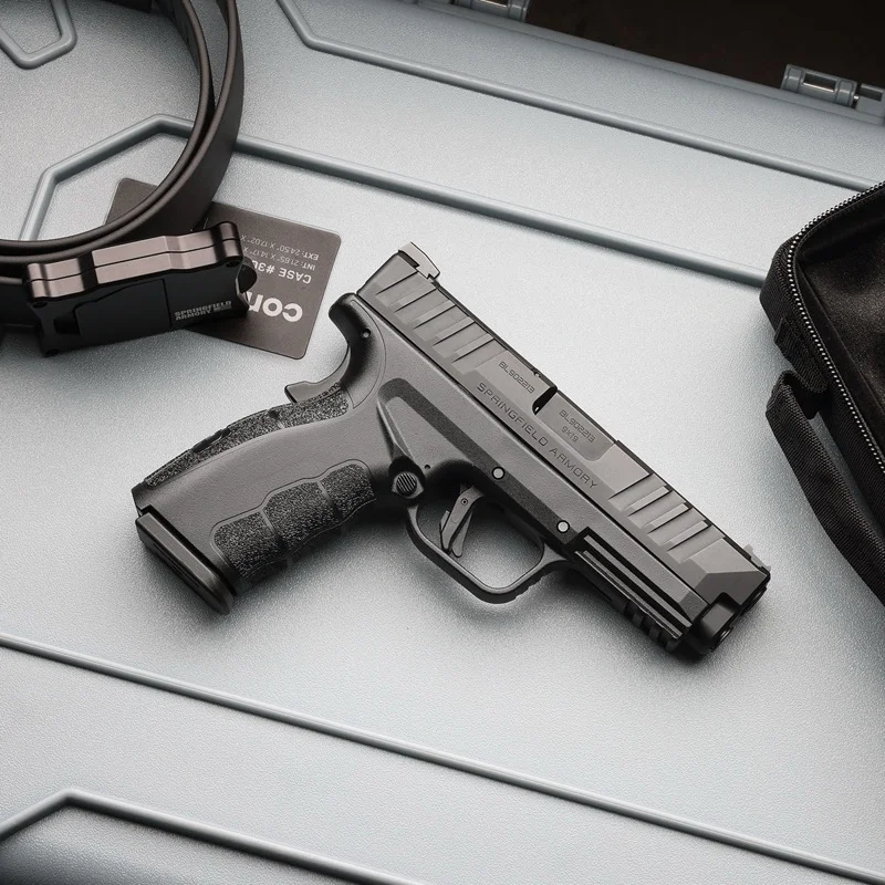 Springfield XD Mod.4 OSP on a desk with gear and accessories