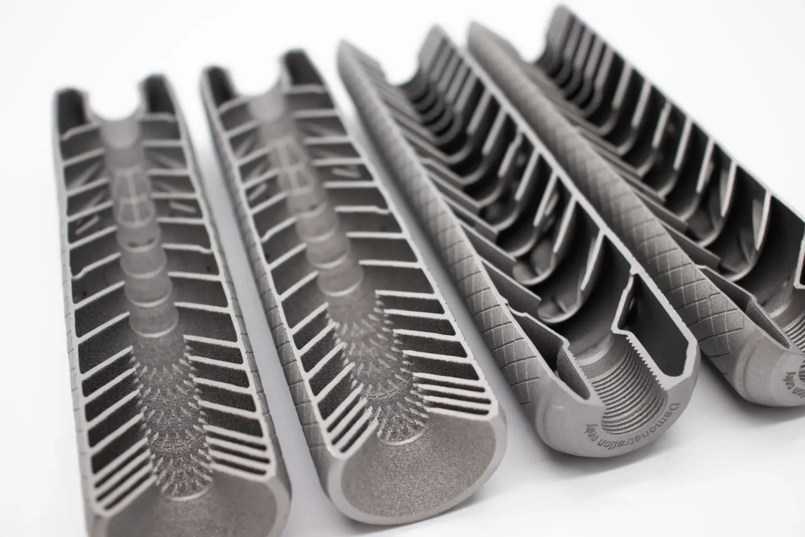 Sectioned 3D-printed metal suppressor baffle cores showing internal blast chambers and baffle geometry