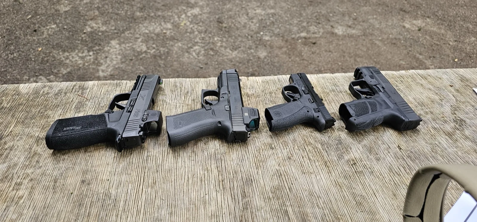 Micro carry pistol lineup on a range bench including the Smith & Wesson Bodyguard 2.0