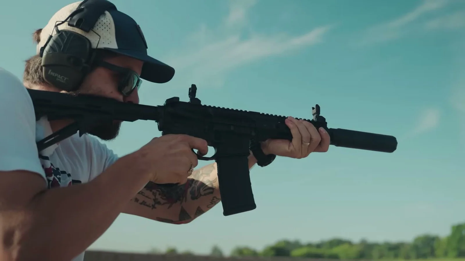 Shooter firing the suppressed M&P15 AXE .300 Blackout with folding sights deployed at an outdoor range