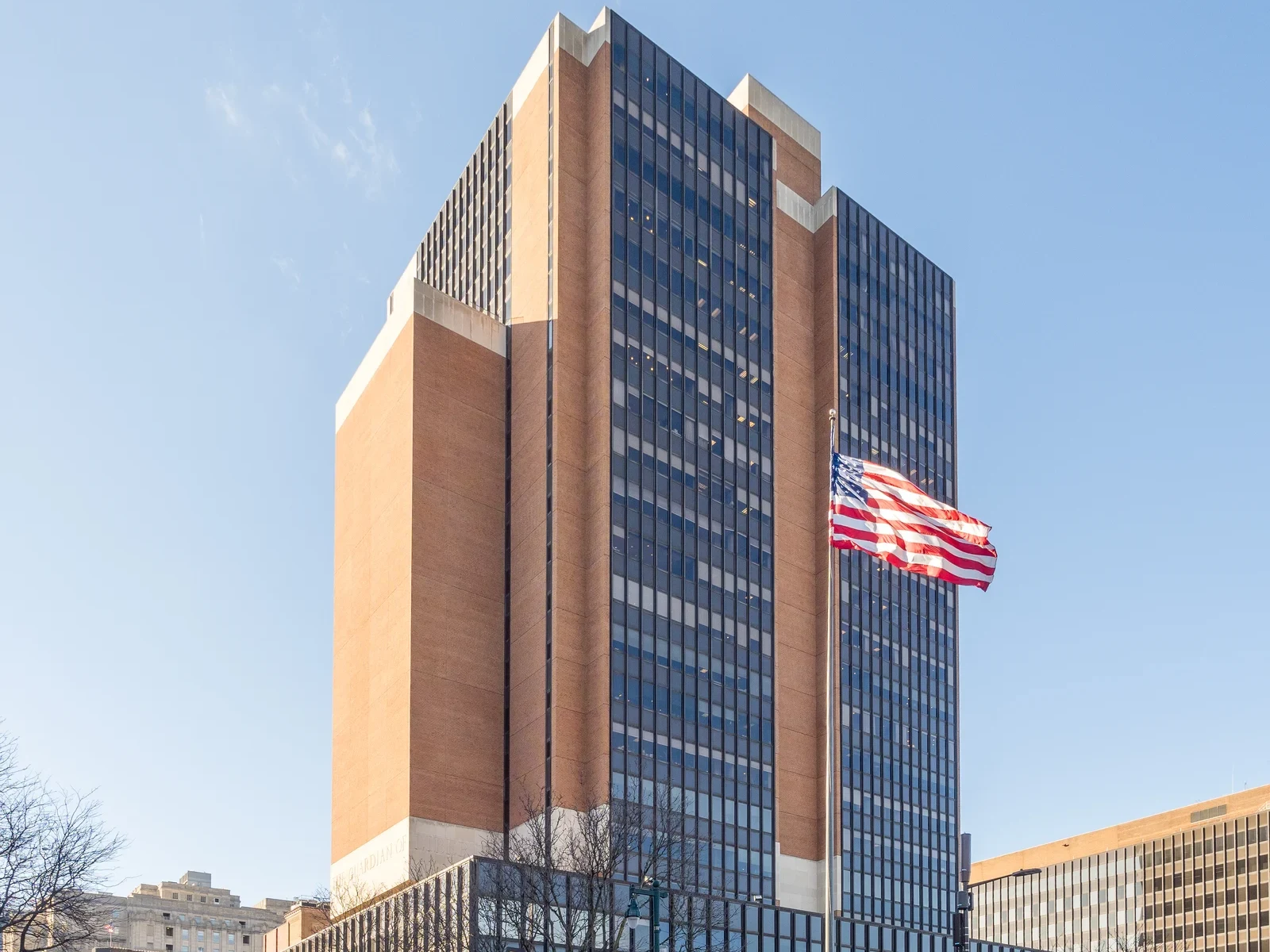 The James A. Byrne United States Courthouse in Philadelphia, a brick and glass tower with an American flag flying at the corner of 6th Street