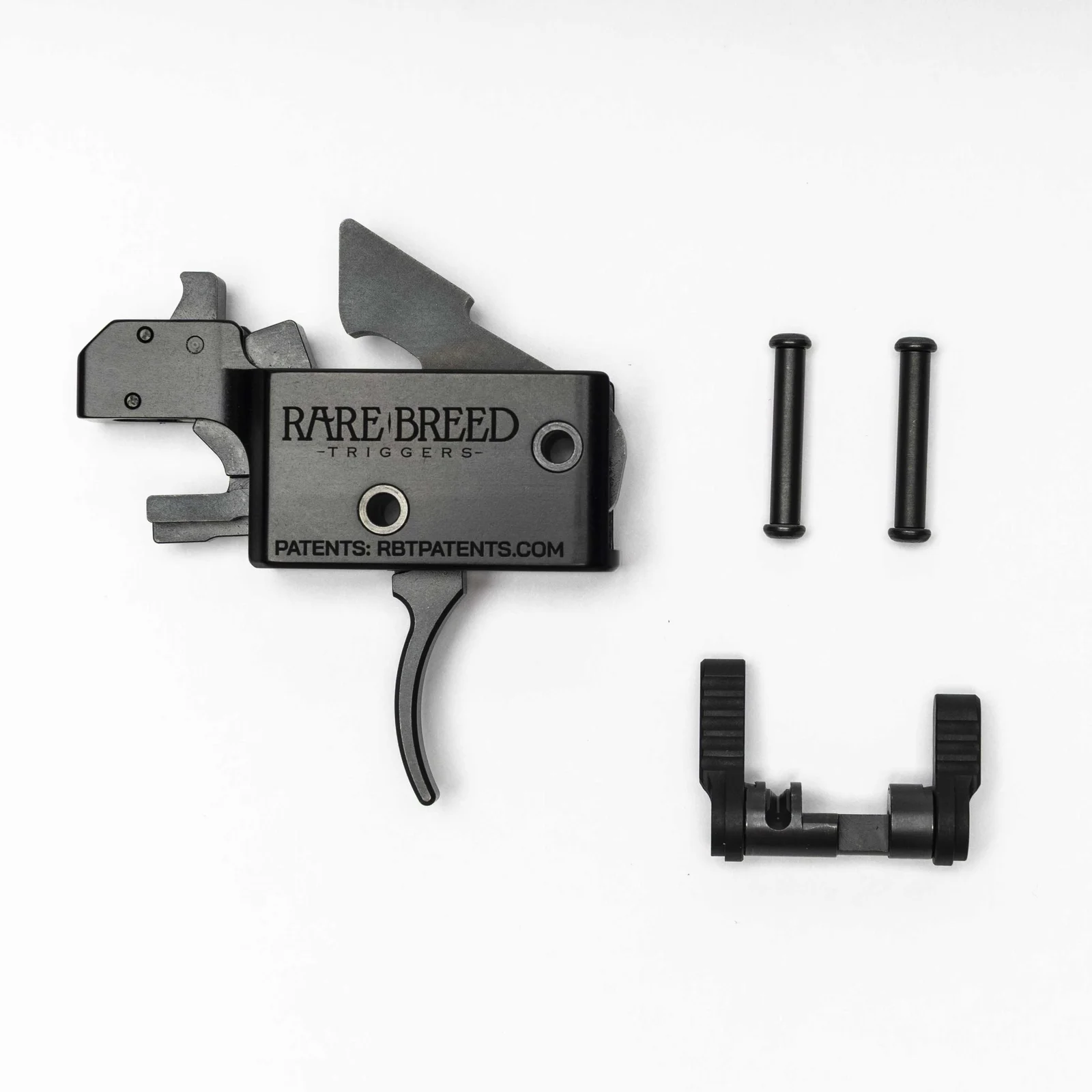 Rare Breed FRT-15L3 forced reset trigger cassette laid out with its two anti-walk pins and ambidextrous 3-position selector