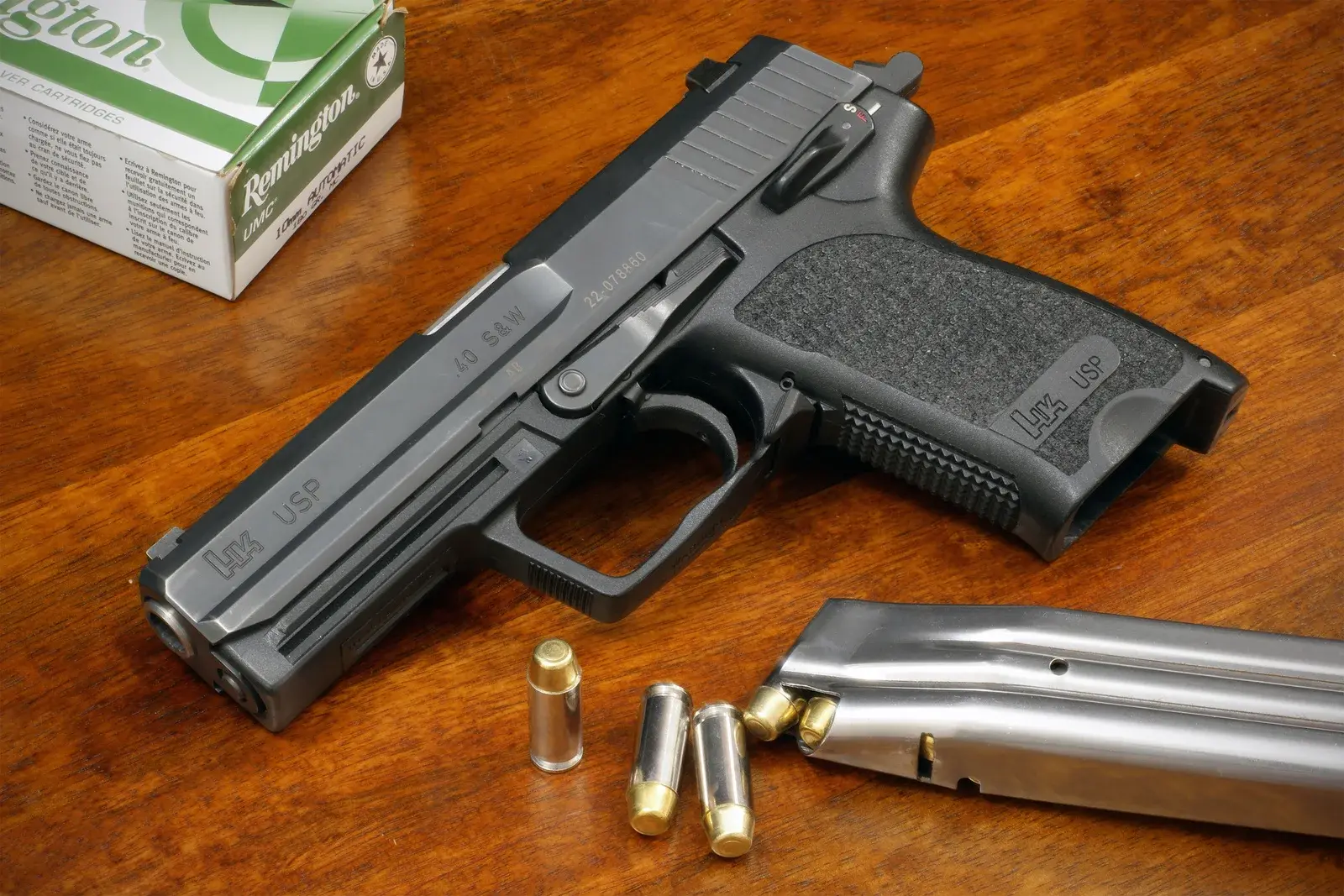 Standard Heckler and Koch USP pistol photographed beside its magazine and cartridges