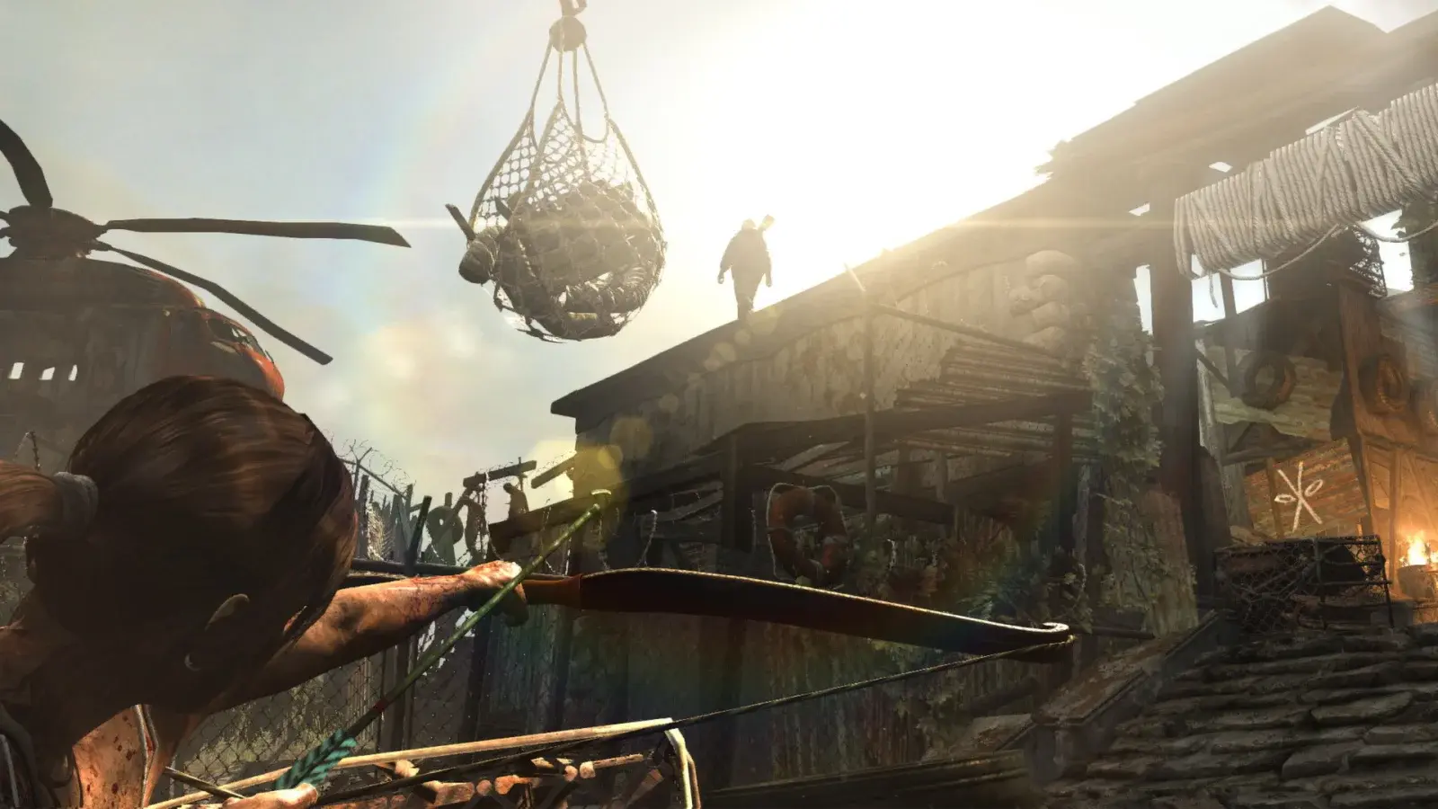 Lara Croft drawing a bow in a bright shantytown in Tomb Raider 2013