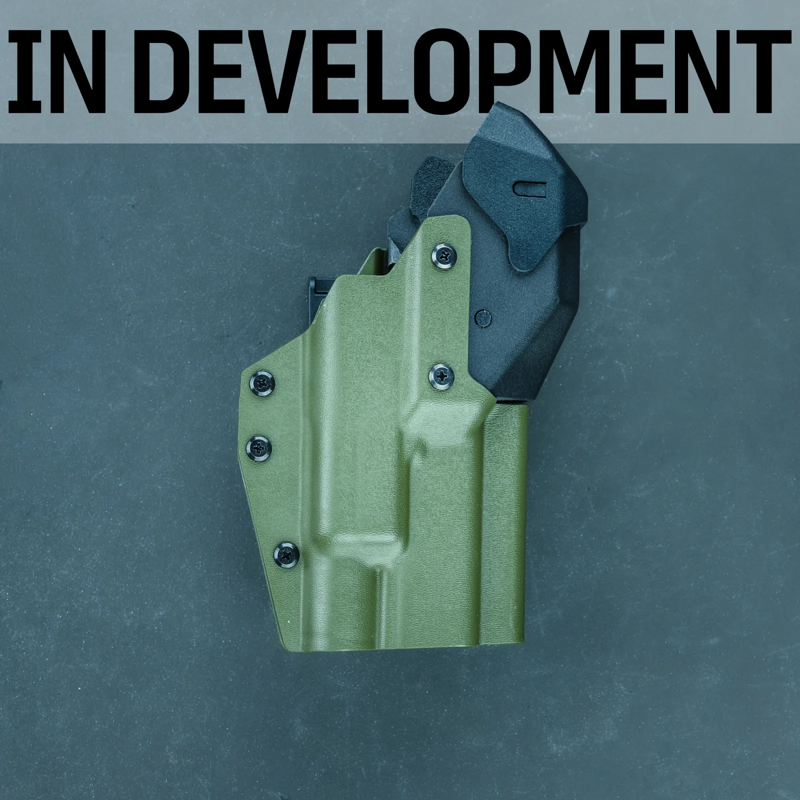 T.REX Titan development prototype in OD green Kydex with a black retention hood, labeled IN DEVELOPMENT