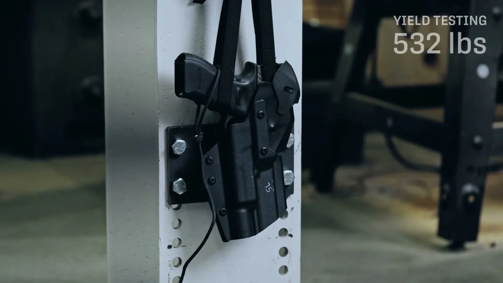 T.REX Titan holster bolted to a test fixture with a strap pulling a Glock pistol upward, load cell reading 532 lbs