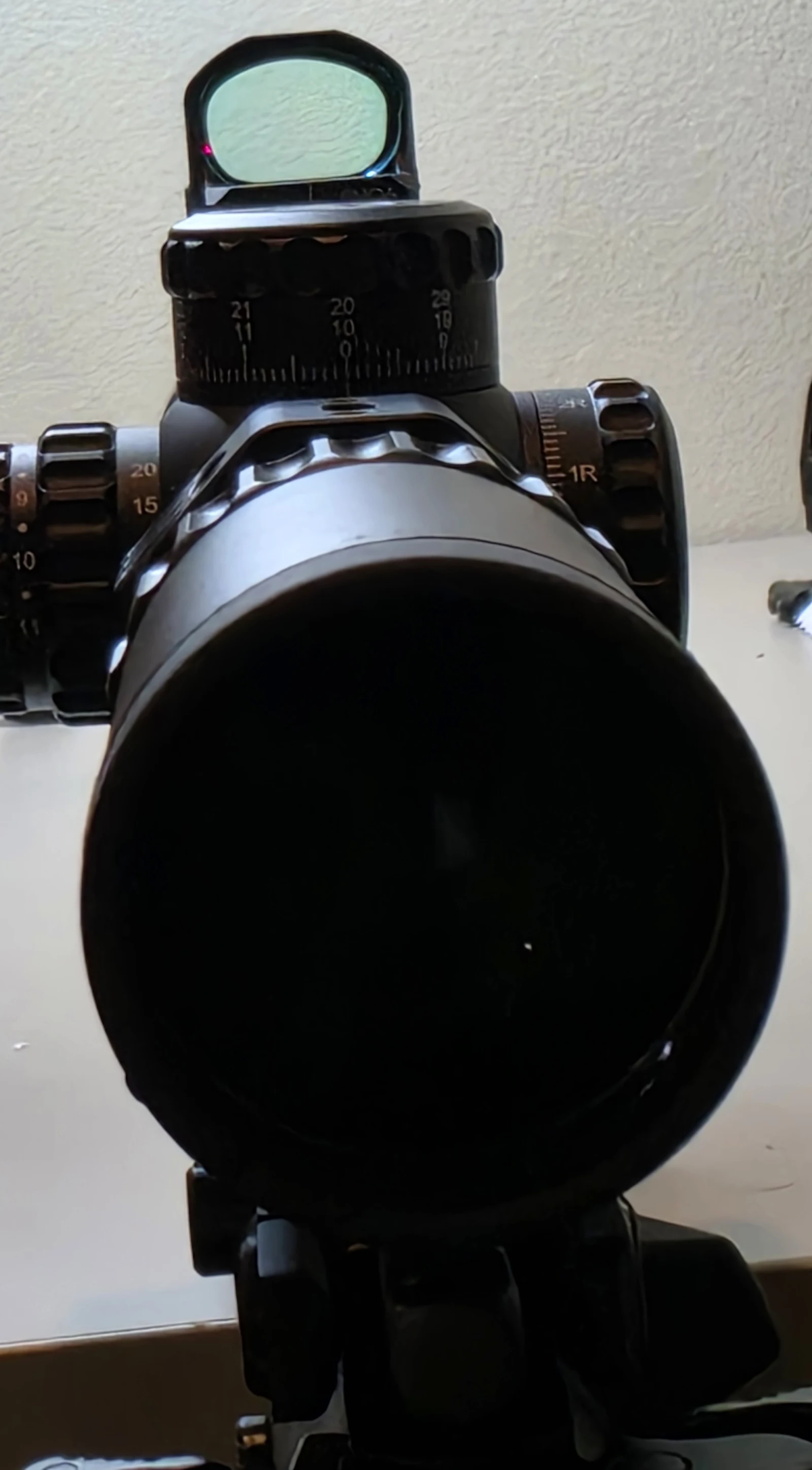 Vector Optics Frenzy FM red dot mounted on top of the Continental 2-12x44 scope ring, viewed straight down the scope tube with the elevation dial and windage turret below it