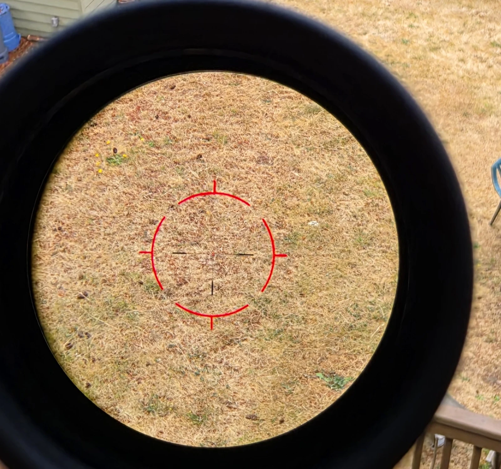 Through-the-glass view of the Vector Optics Continental VET-RAR 2 reticle at low magnification showing the illuminated red rapid ring with hash marks