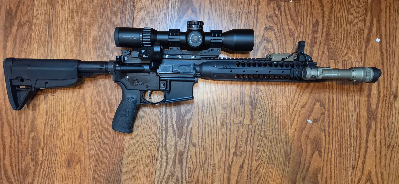 Vector Optics Continental 2-12x44 mounted on an LWRC rifle with a one-piece 34mm mount, a 45-degree offset red dot beside the rear of the scope, and a Cloud Defensive REIN light on the handguard