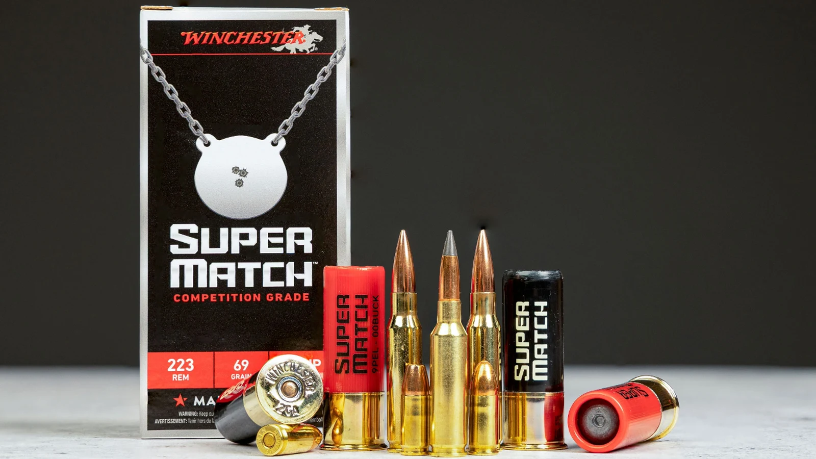 Winchester Super Match 223 Rem 69 grain box beside loose 12 gauge shells, rifle cartridges, and pistol rounds