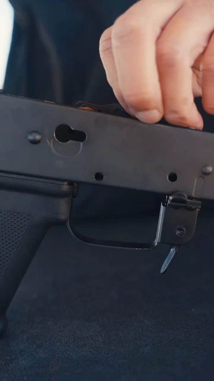 Close view of an AK receiver fire-control area with the trigger, guard, and selector lever