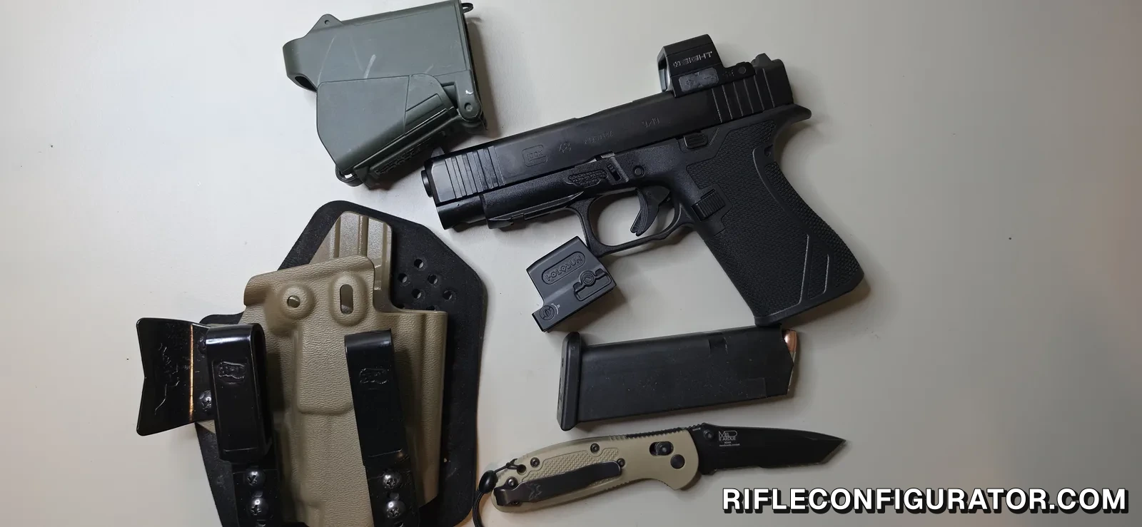 Glock 48 with an enclosed red dot mounted, laid next to a tan kydex appendix holster with a soft backer, a spare optic, a magazine, and a folding knife