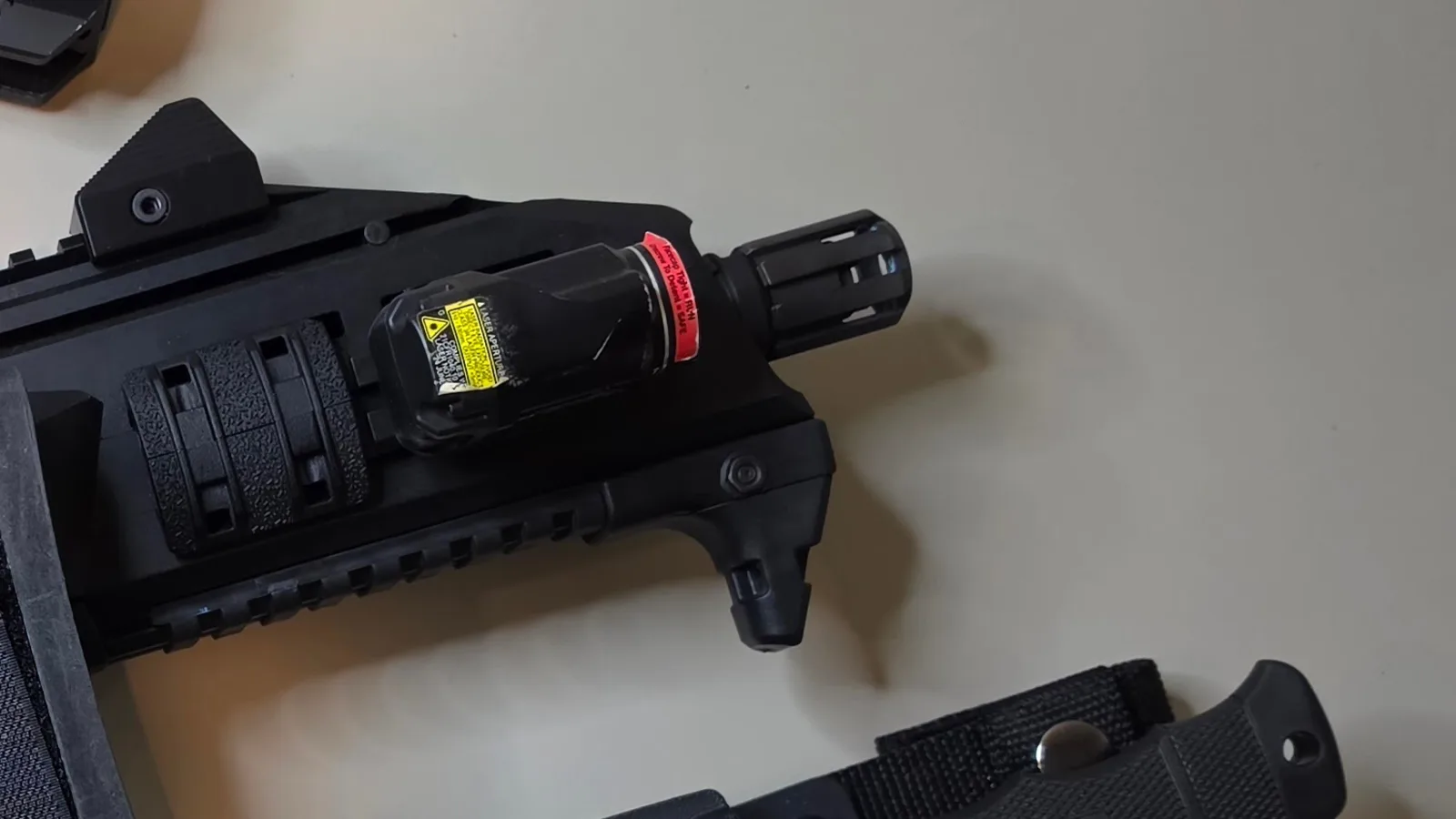 Streamlight TLR-8A G weapon light with a green laser aperture clamped to the forward rail of a CZ Scorpion handguard, next to the flash hider and an angled hand stop