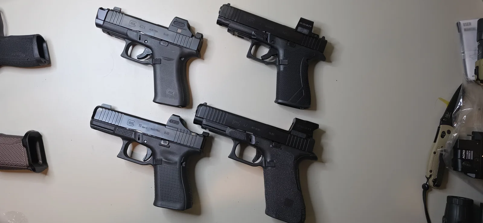Four Gen5-era Glock pistols with red dots mounted, spanning slim-frame 43X and 48 models and compact and full-size MOS models