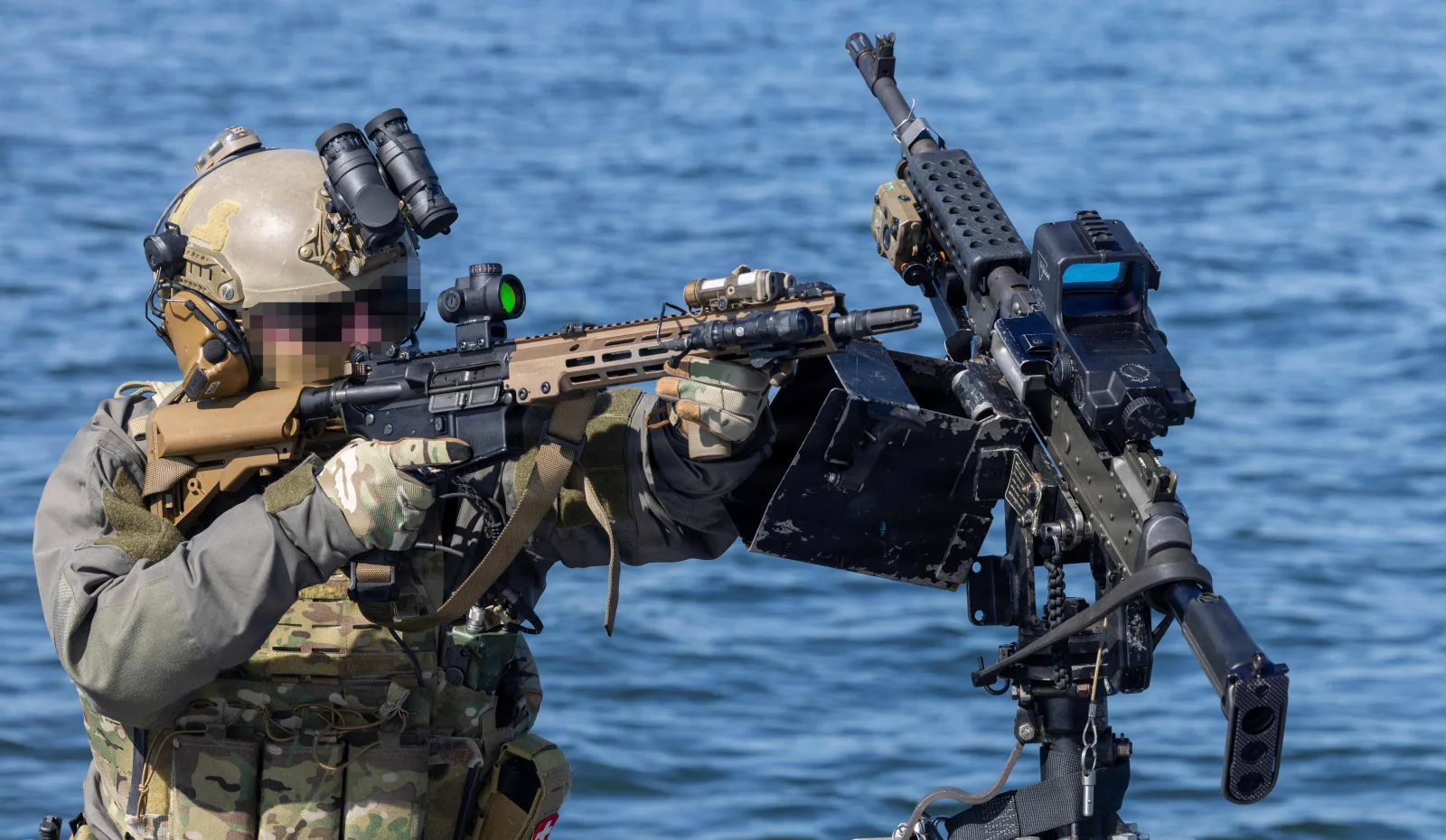 Coast Guard Maritime Security Response Team East operator aiming an FDE M-LOK railed 5.56 carbine with red dot and Scout light during live-fire training on the water