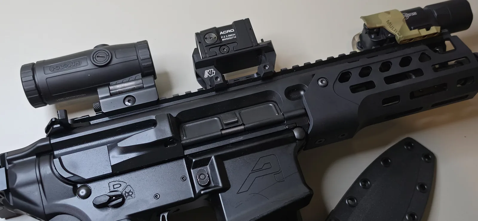 SIG MCX Rattler LT upper mated to an Aero Precision lower, with an Aimpoint Acro P-2 on a raised mount, a Holosun magnifier behind it, and a SureFire X300 mounted on the M-LOK handguard